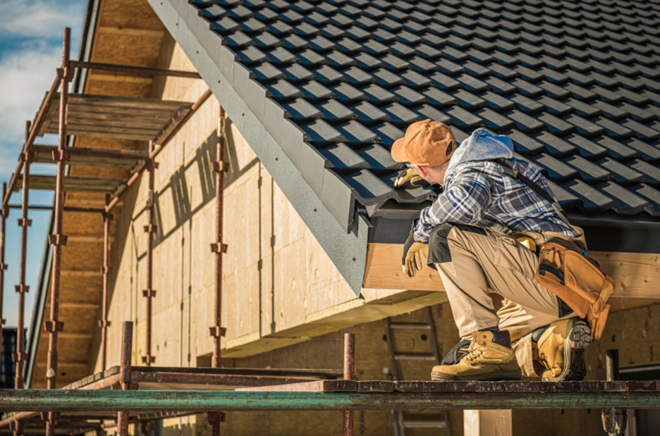 Professional roofing inspector examining shingles on a house roof in Edmonton.