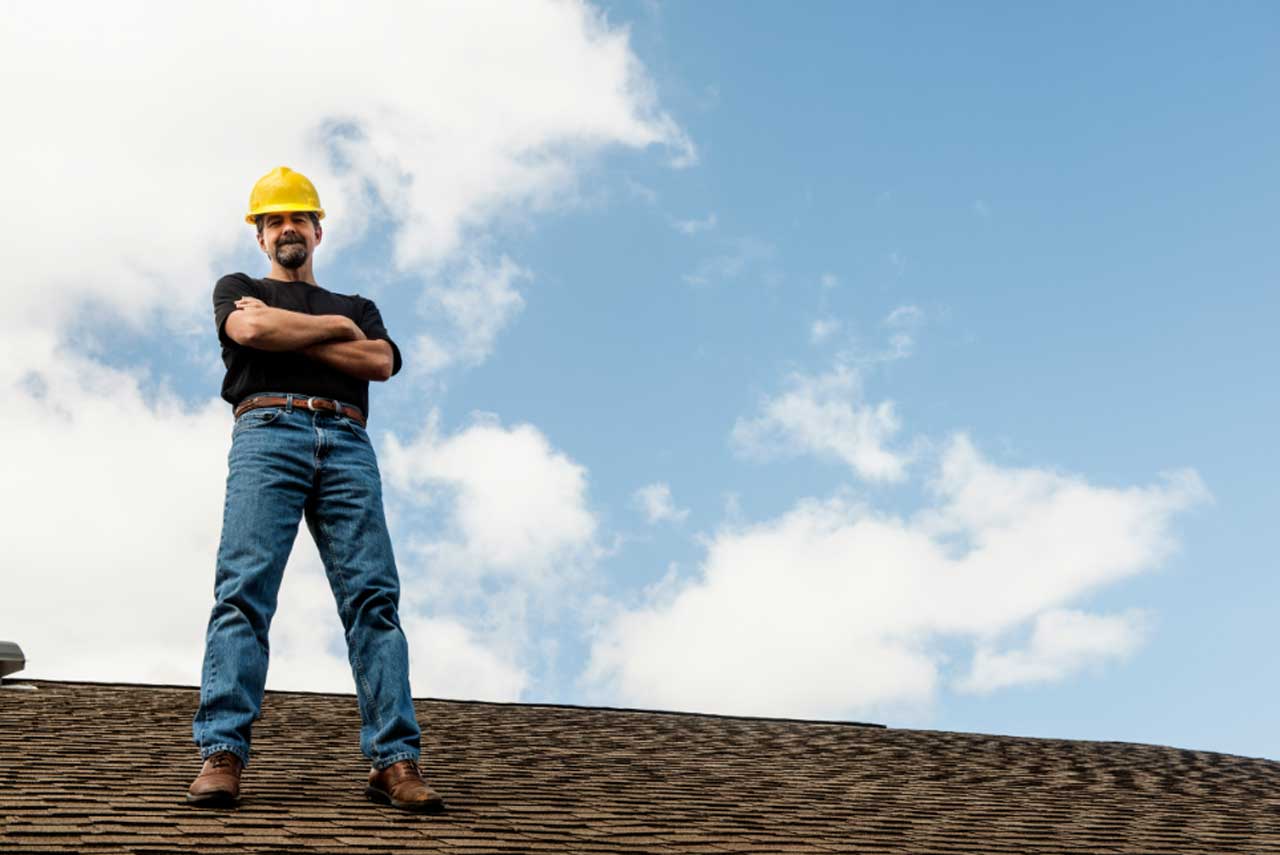 A confident roofing contractor standing on a roof, demonstrating Silverline Roofing's professionalism and expertise in Edmonton.