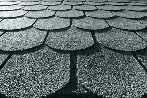 Close-up of scalloped asphalt shingles in a decorative pattern, showcasing the unique design and texture of this roofing style.