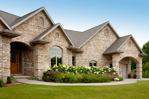 Beautiful brick home with a well-maintained roof featuring asphalt shingles, showcasing the importance of selecting the right roof shingles for aesthetic appeal and durability.