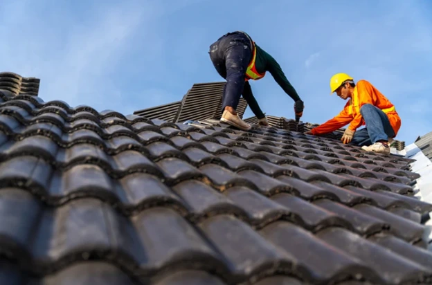 Roofing professionals installing new roofing materials on a home, ensuring durability and quality.