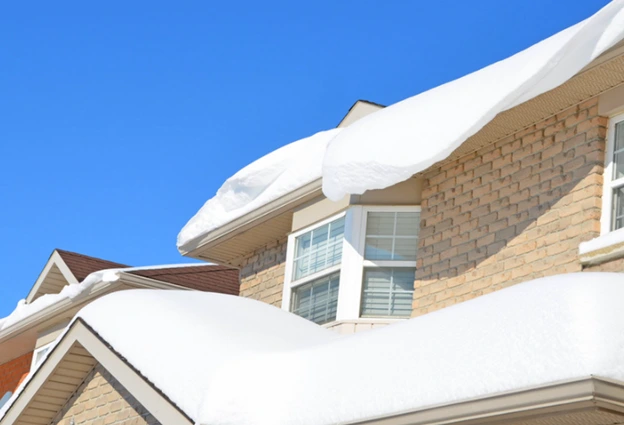 Residential roof with heavy snow buildup, highlighting the need for durable, winter-resistant roofing.