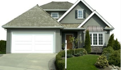 A beautiful grey stucco home with a luxury composite shake or slate-style roof, installed by Silverline Roofing Ltd, isolated on a white background